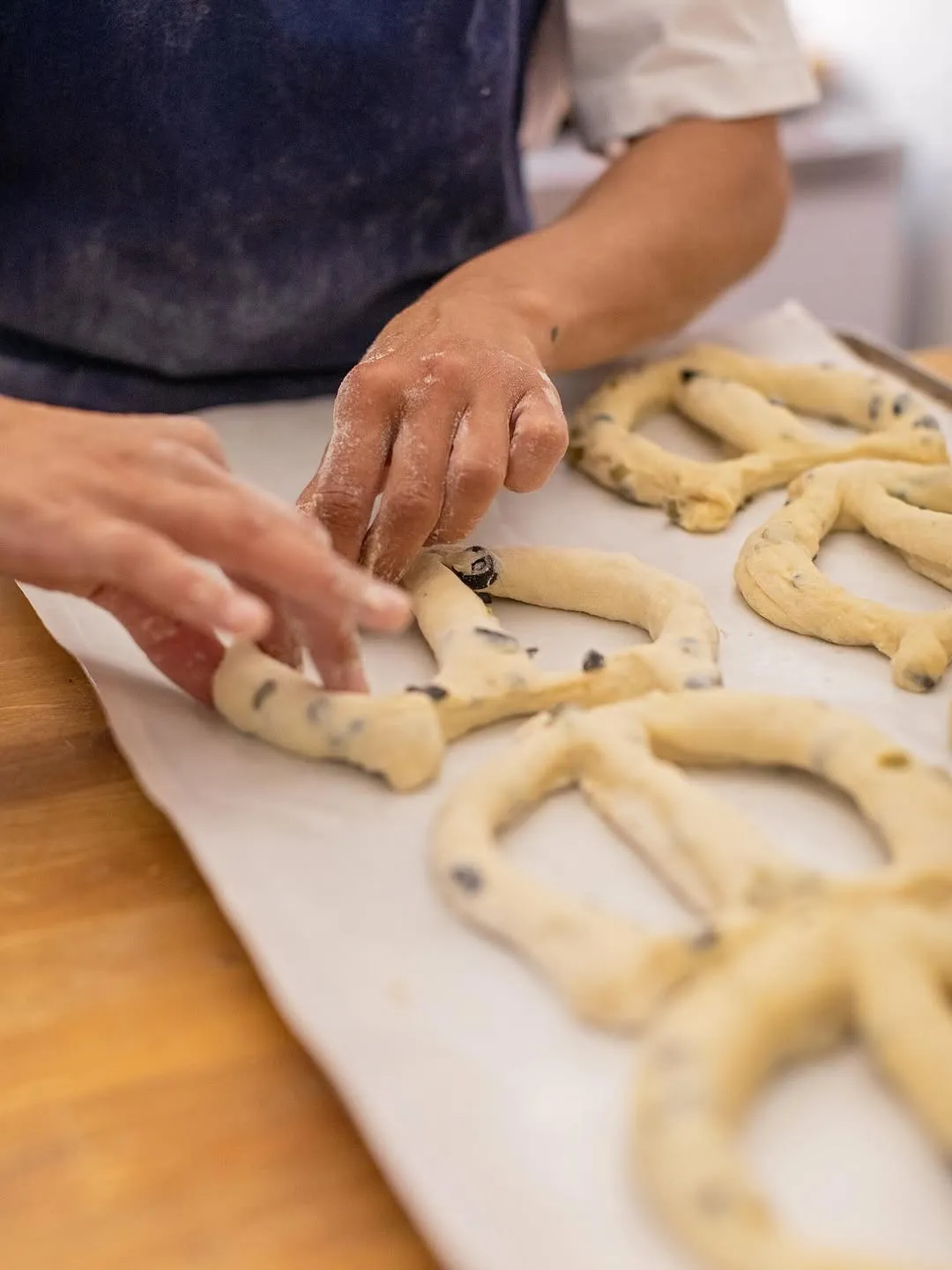 Mans obrint els talls d’una fougasse abans de coure-la.